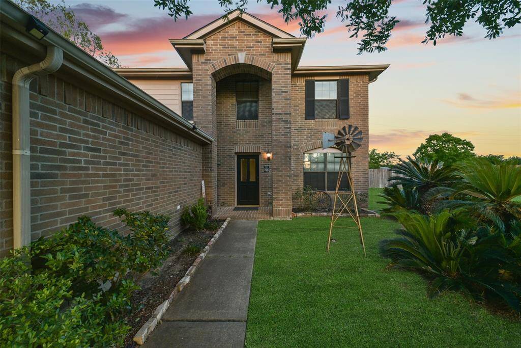 The welcoming path leads to a charming covered entryway, surrounded by low-maintenance landscaping and thoughtful Texas touches.