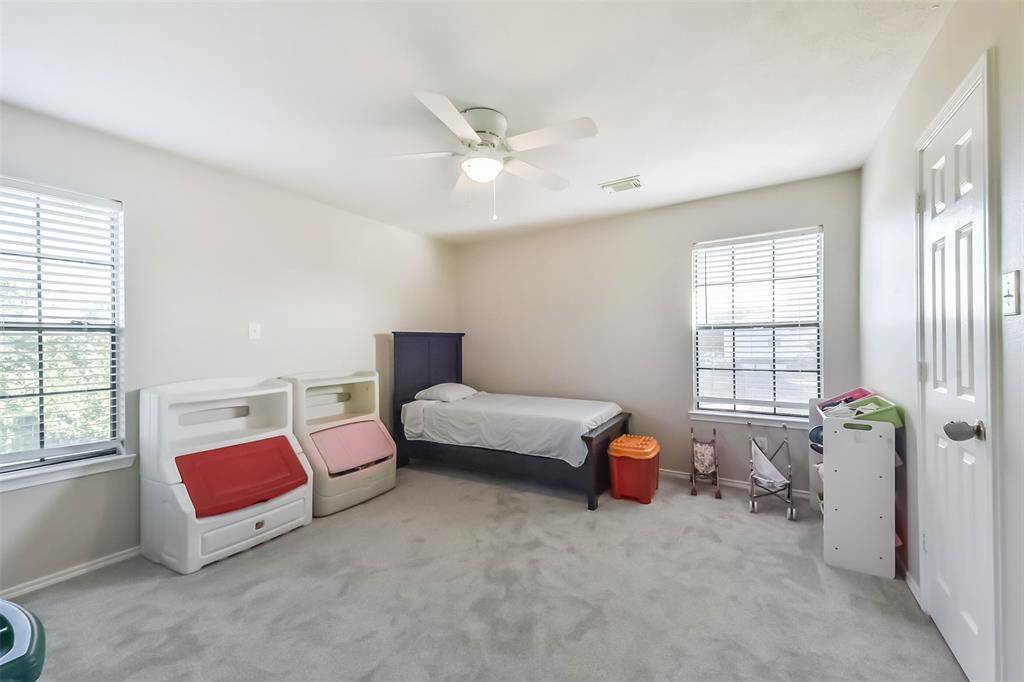 Spacious and sunlit, this upstairs bedroom offers plenty of room for sleep and play—with two large windows and tons of floor space for furniture or fun.