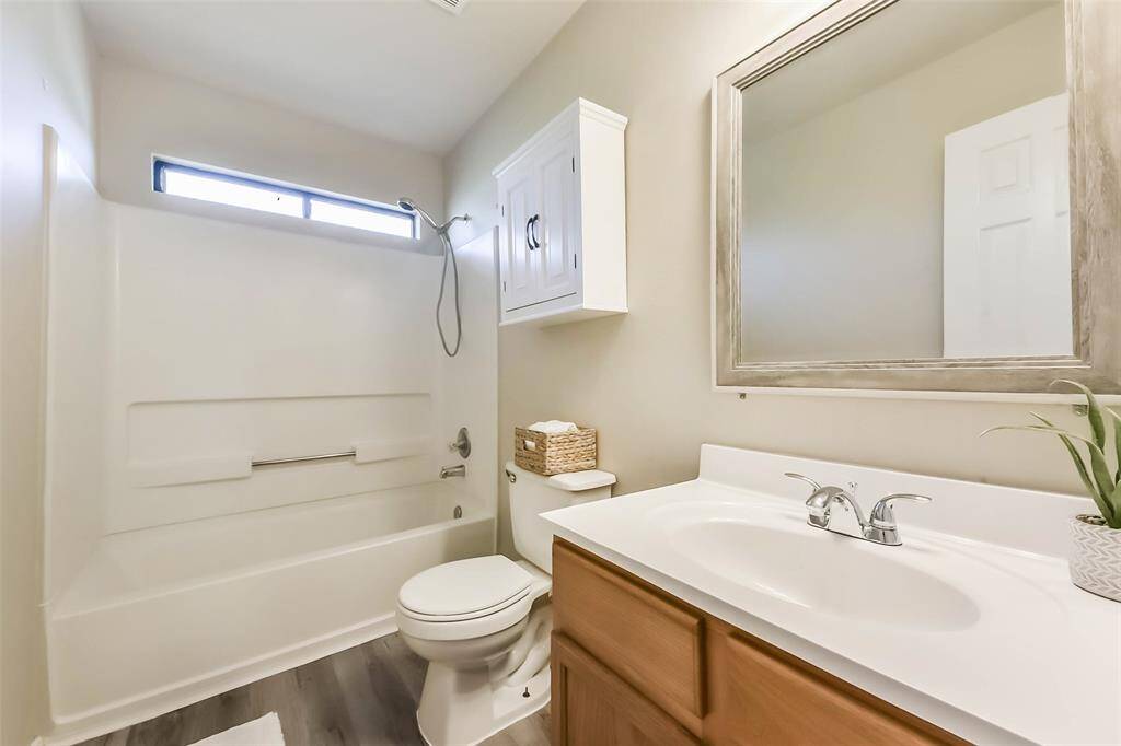 The upstairs bathroom, conveniently located between two bedrooms, features a spacious vanity, modern vinyl plank flooring, and a sleek tub/shower combo—perfect for busy mornings or winding down at night!