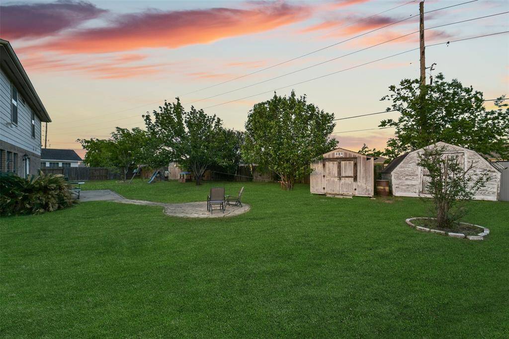 With two storage sheds and wide open green space, this backyard has room for everything—gardening, hobbies, and all the kids’ toys too.