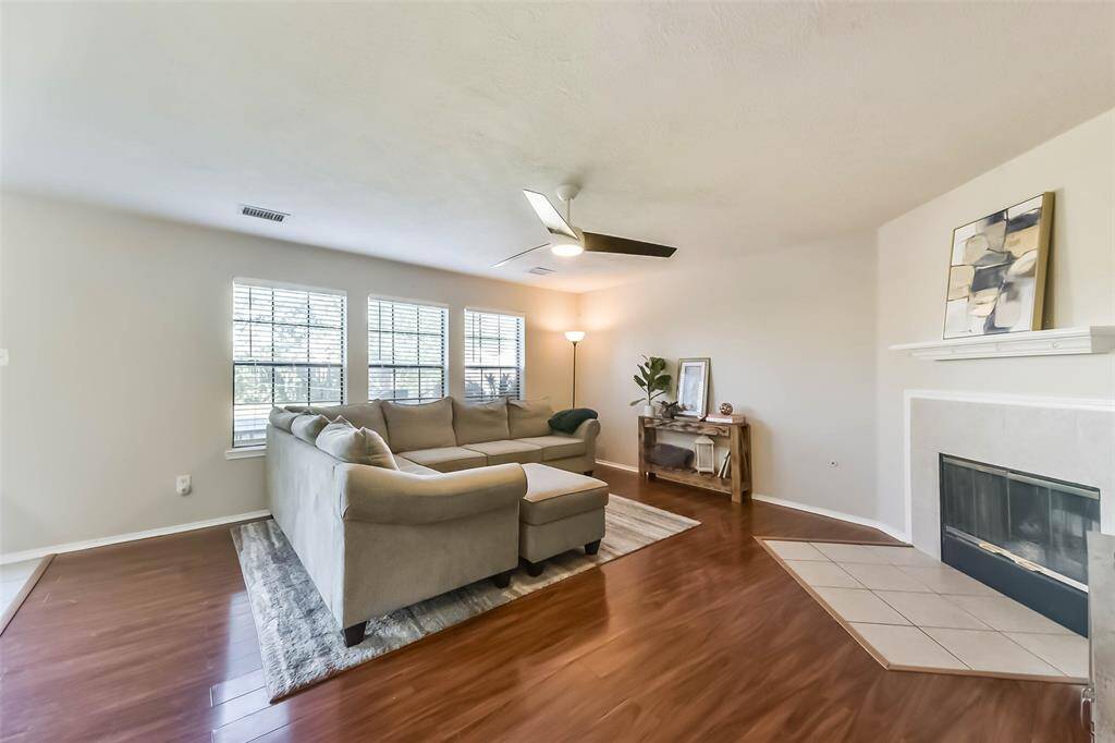 Bright, airy, and ready for your crew to cozy up! This spacious living room features a wall of windows, a modern ceiling fan, and a corner fireplace that adds warmth and charm to your everyday moments.