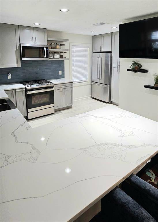 The kitchen flows effortlessly into the living area, creating an open-concept layout that’s perfect for easy family gatherings and seamless entertaining.