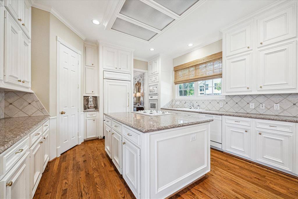 The center island is a great preparation space and the door to the left leads to the walk-in pantry.