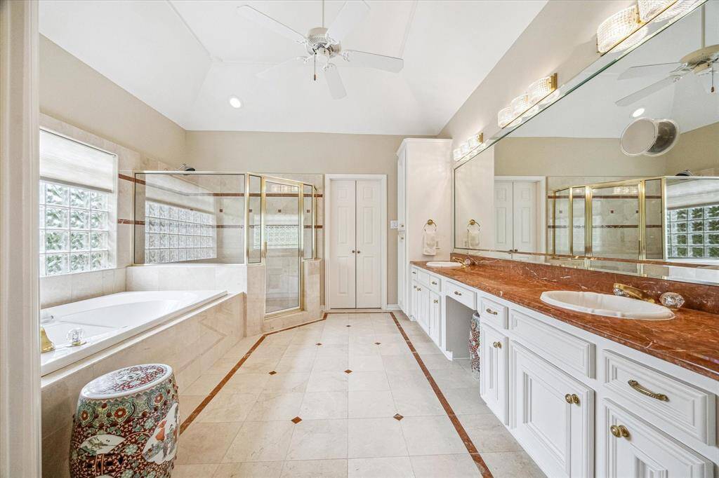 The spa style bath has an elegant touch, double sinks, a vanity with knee space, soaking tub, large shower and a enormous closet.