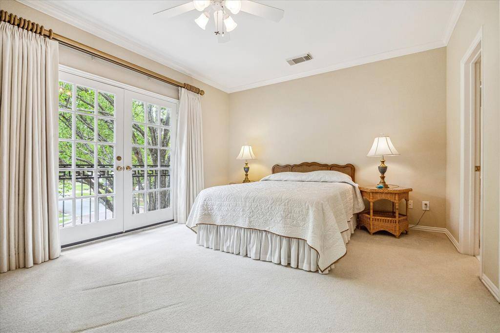 This front bedroom has direct bath access on the right and the double French doors create a birds eye view of the pretty trees.