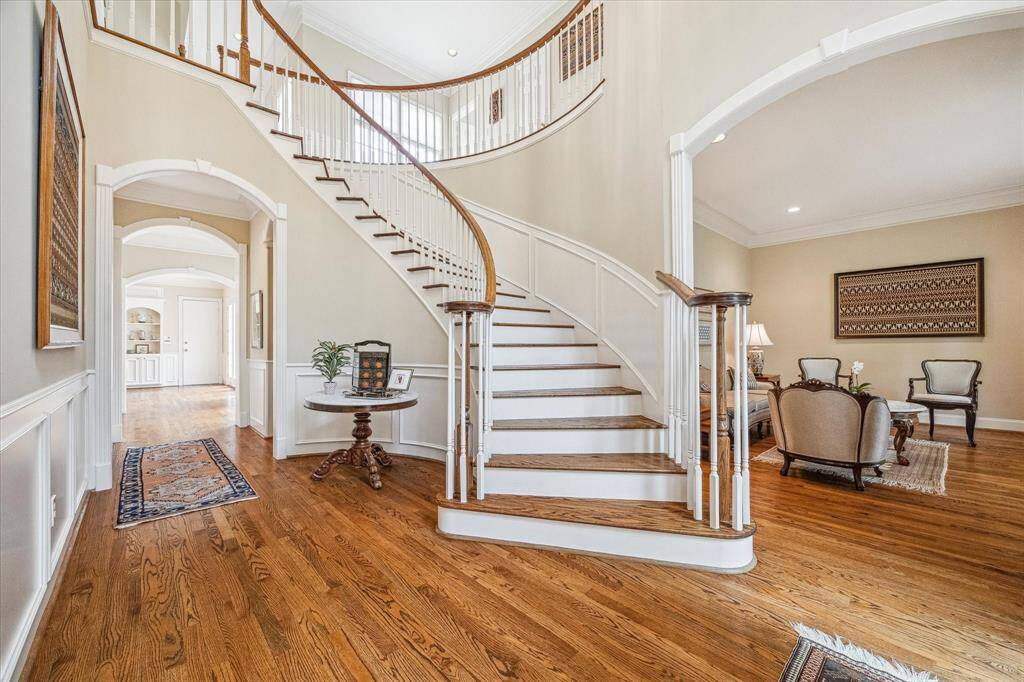 The gracious entry foyer opens to the living room on the right, straight ahead to the family room and to the left the dining room. Note the beautiful stairway and the soaring ceilings viewing the 2nd floor landing.