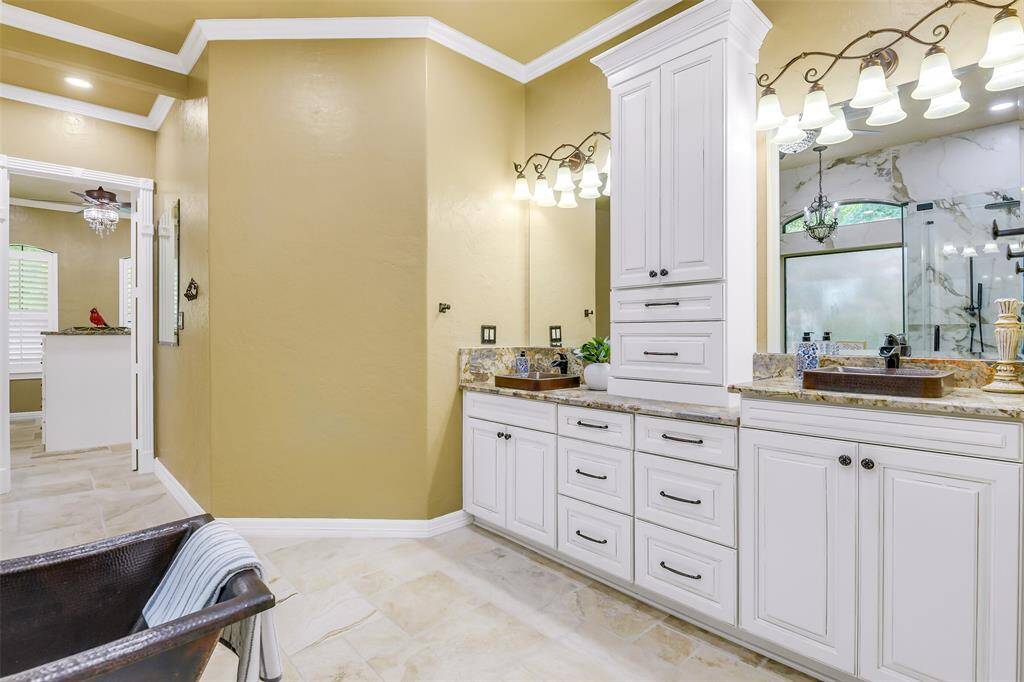 This is the primary bath with dual sinks, HUGE walk in shower, stunning Copper tub, private vanity area and more.
