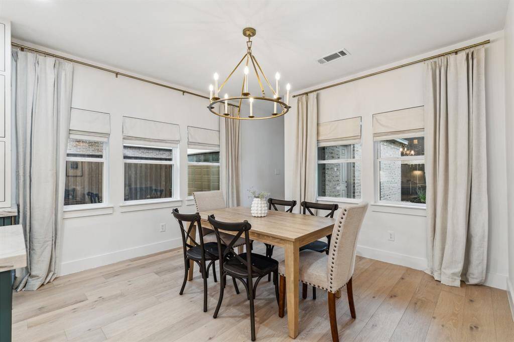The large breakfast room can easily fit a table for 6 or more. Stunning windows with roman shades and curtains also adorn this lovely space.