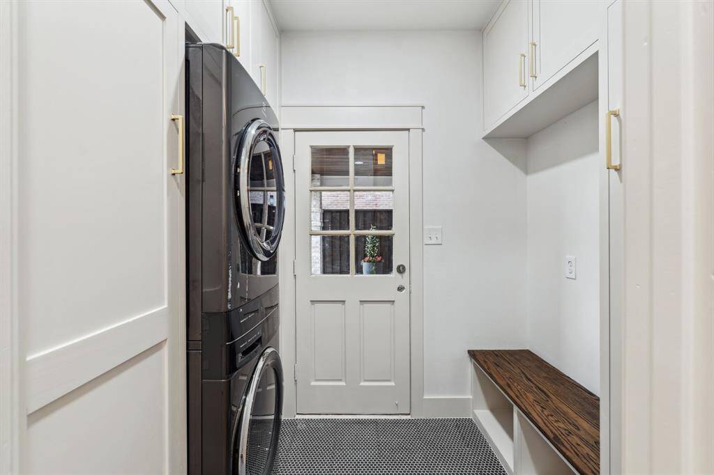 The custom utility room doubles as a mud room area and has custom cabinetry throughout and a brand new washer and dryer. The door leads to the massive porte-cochere.