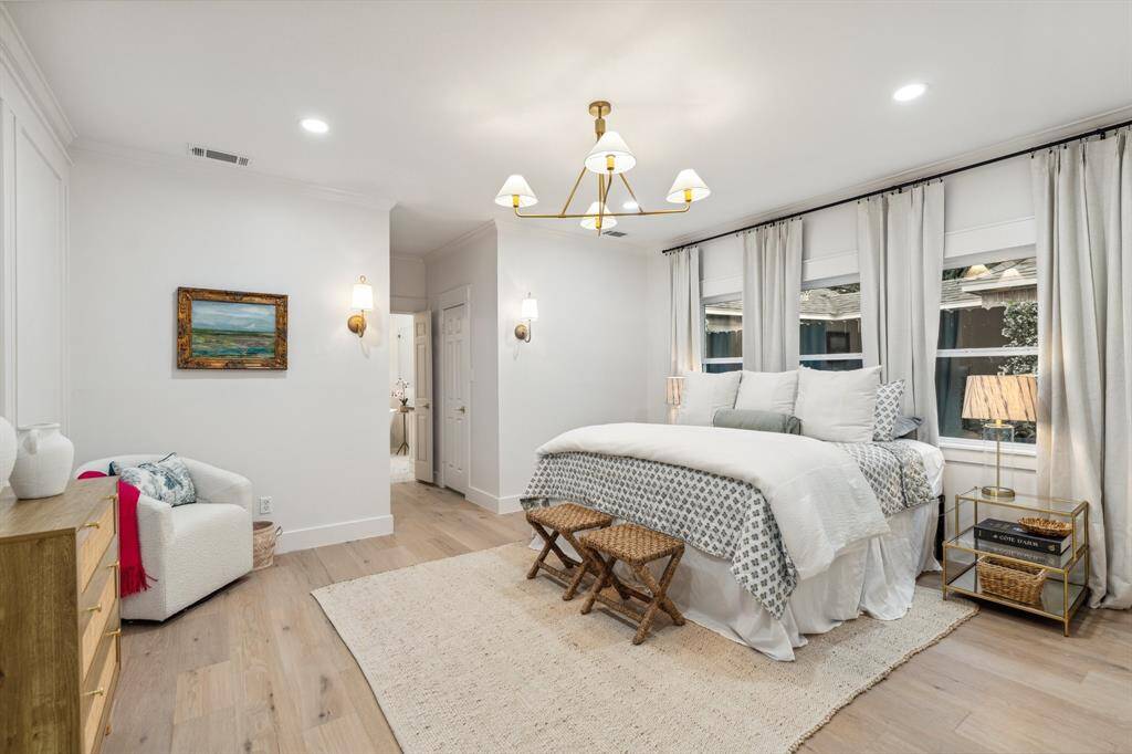 This primary suite is a true retreat with hardwood floors, custom lighting, 3 large walk-in closets, and a primary bathroom that is second to none.