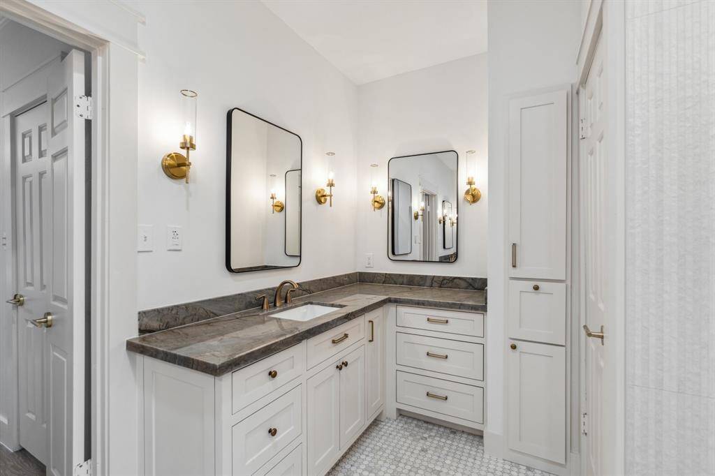 Quartzite counters, sconce lighting, marble tile floor, new hardware, and tons of storage space make this space stunning and functional.