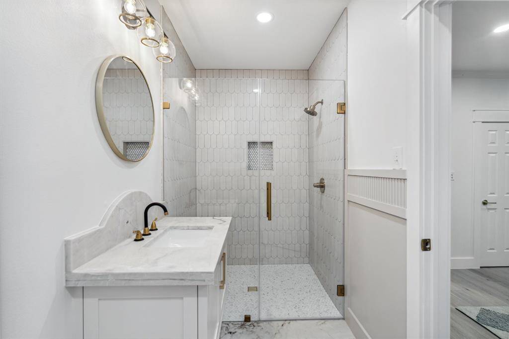 Stunning en-suite bathroom with full shower, new vanity, quartzite counters, all new fixtures, and all new tile.