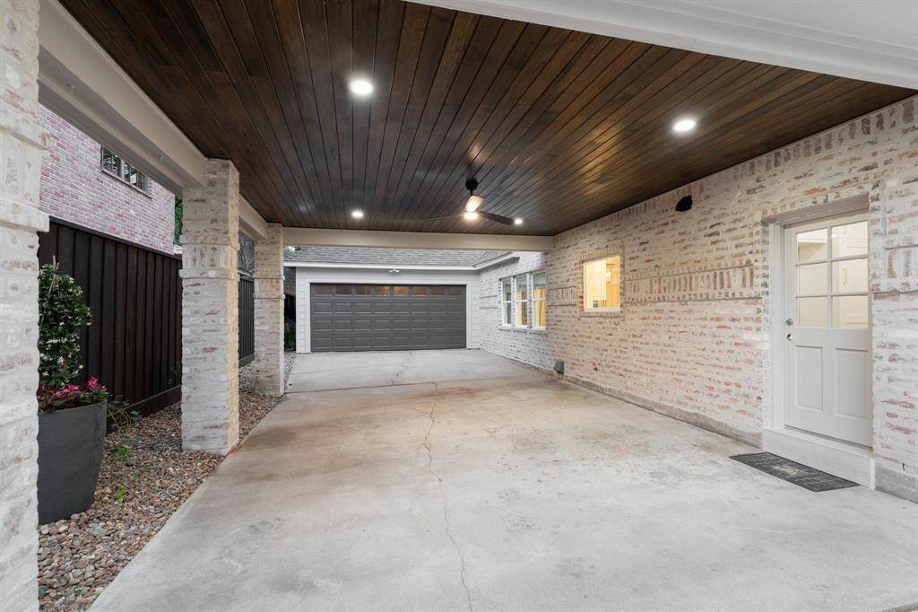 This huge porte cochere is a great space to park cars, hang out, and park your car to unload your groceries through the utility room door. All new lighting and ceiling fan along with stained wood plank ceiling.