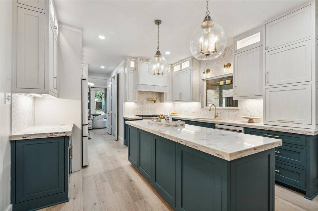 This kitchen is a show stopper with quartzite counters, custom soft close cabinetry, marble backsplash, new GE cafe appliances, and incredible lighting.