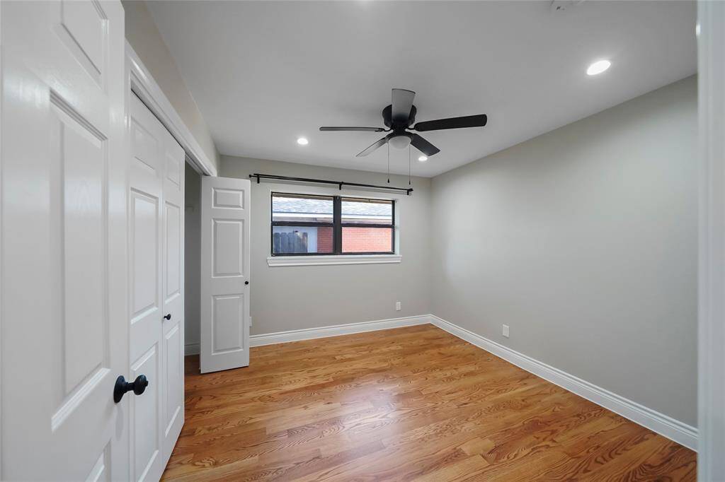 Here’s a look at one of two secondary bedrooms, featuring solid wood flooring, recessed lighting, a large closet, and a ceiling fan. Plus, there’s no carpet anywhere in this home!
