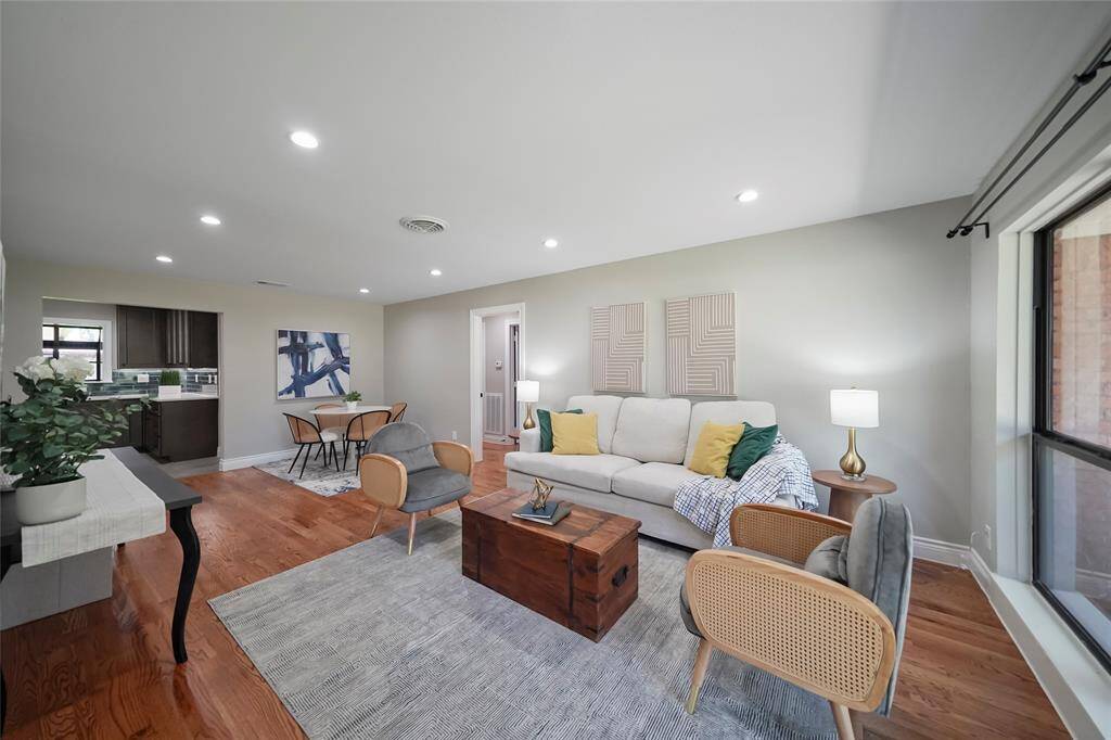 Upon entry you step into the open living room/dining room combo with wood flooring, recessed lighting and large windows for an abundance of natural light. Not pictured behind the front door is a large walk-in storage closet.