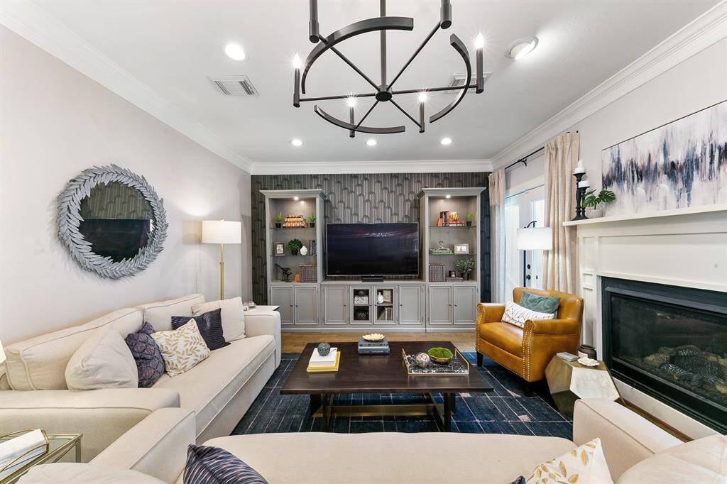 This beautiful living space features an incredible accent wall, gas burning fireplace, recessed lighting and a stunning light fixture.