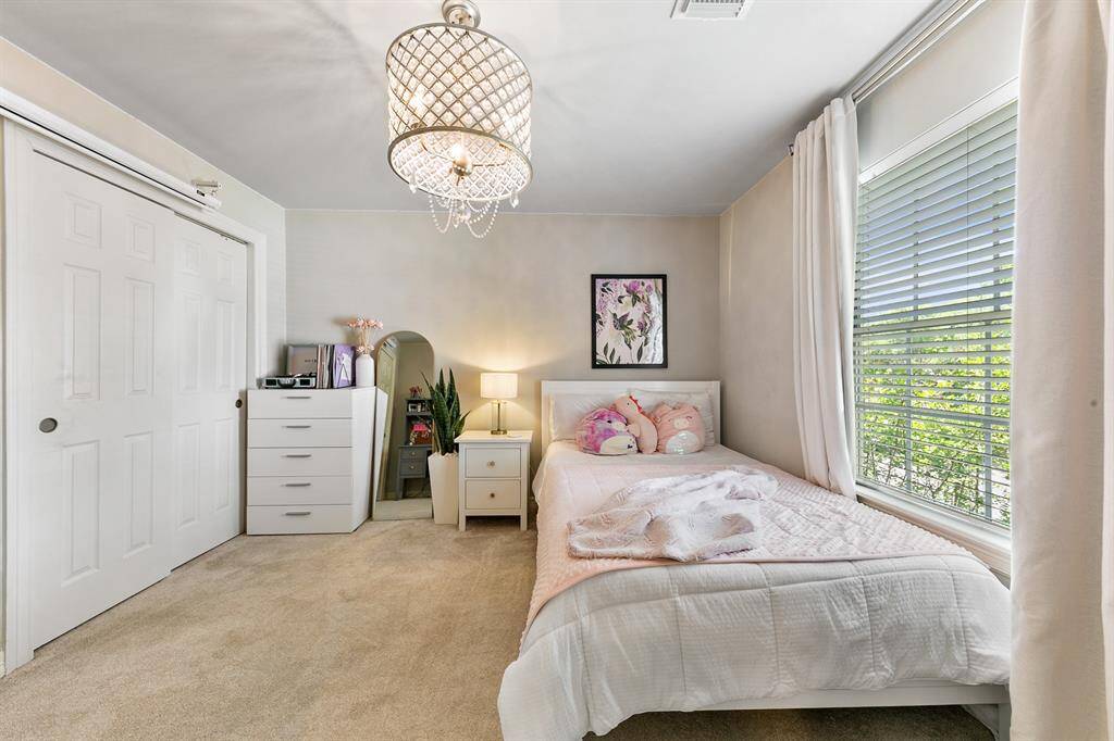 One of the three upstairs secondary bedrooms.  It features an elegant light fixture and large window.