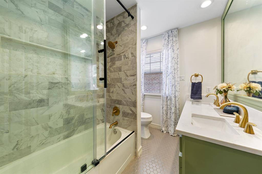 Beautifully updated upstairs full bathroom features gorgeous bronze fixtures, warm color tones, beautiful tile and glass enclosure on the shower/tub combination.