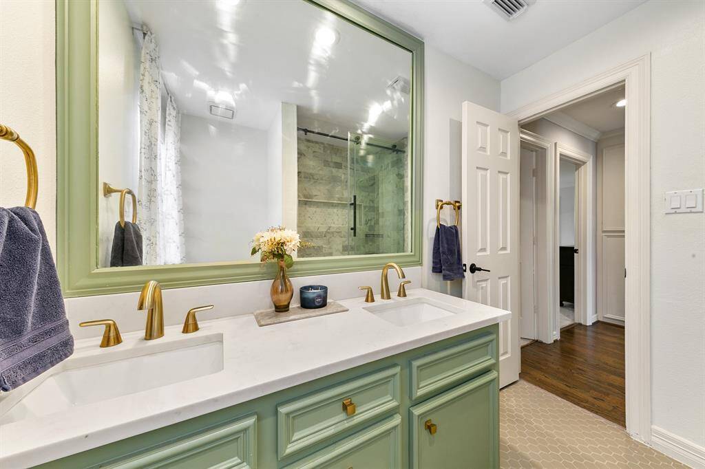 Another view of the full bathroom highlights the two sinks, framed mirror and updated design.