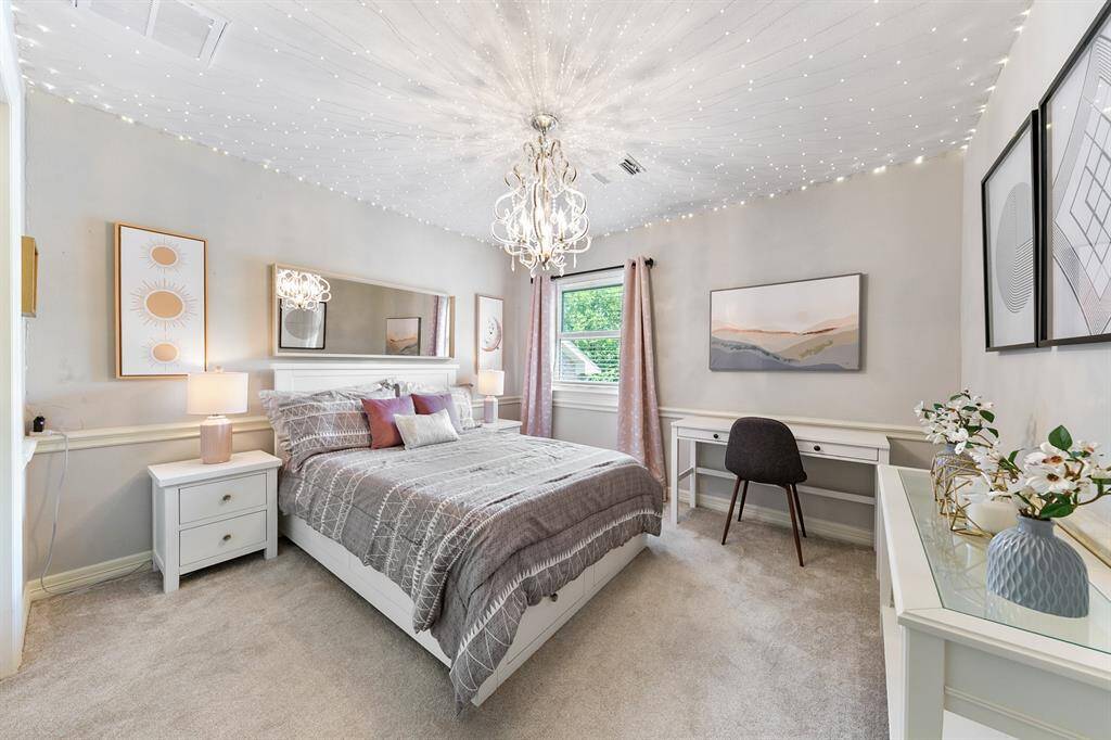 Another upstairs secondary bedroom features chair railing, window overlooking the private backyard and on-trend paint colors.
