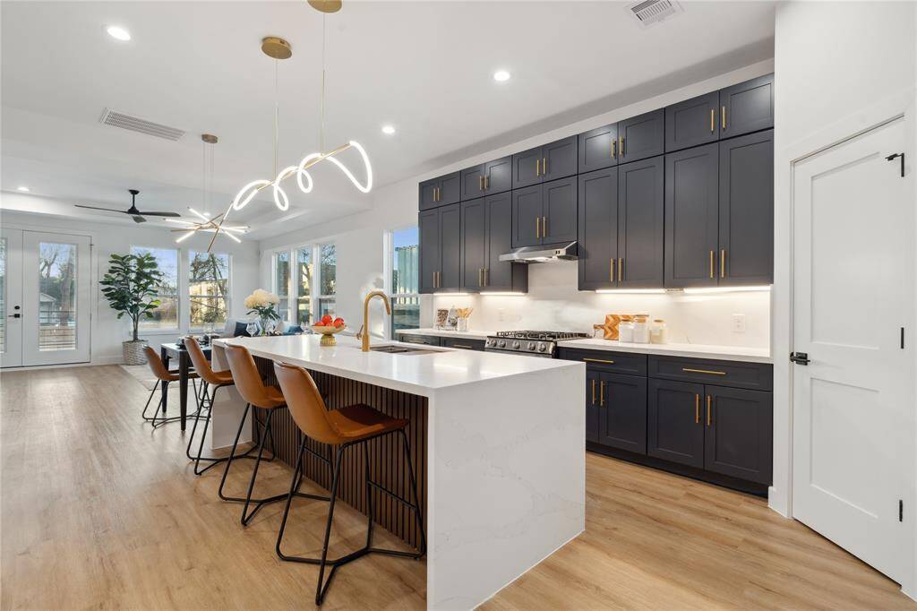 Avant Custom Homes builds a modern masterpiece in Independence Heights this residence has plenty of upgrades from flute panel quartz island to an array of transitional style soft close cabinets and drawers that includes uppers with champagne designer hardware.