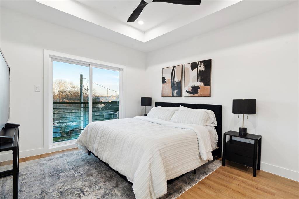 The primary bedroom come equipped with a Juliet balcony and soaring high ceilings.