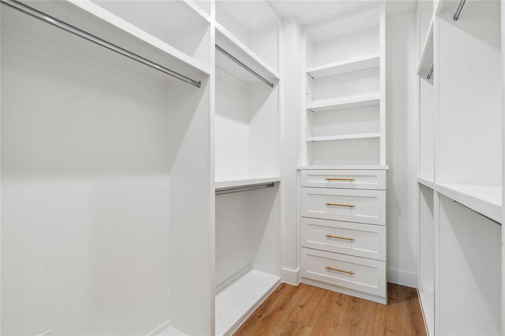The walk in closet has touches of style with metal rods and custom soft close cabinets and shelves.