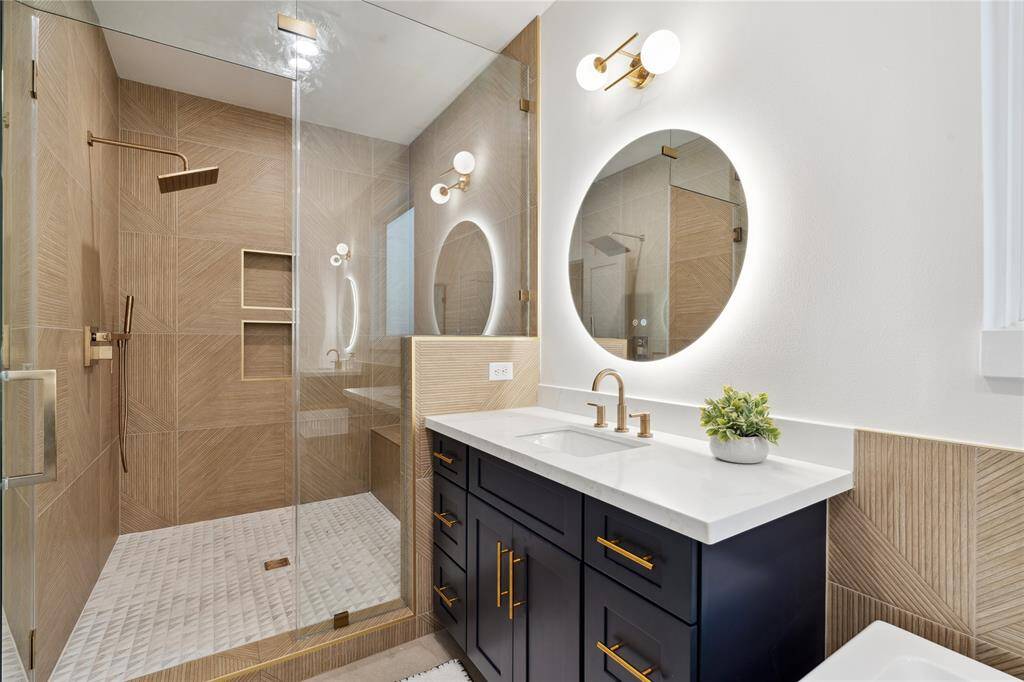 A close look at the walk in shower reveals not only it's beauty with a unique tile pattern with gold schluter trim accents but also it's depth in size.