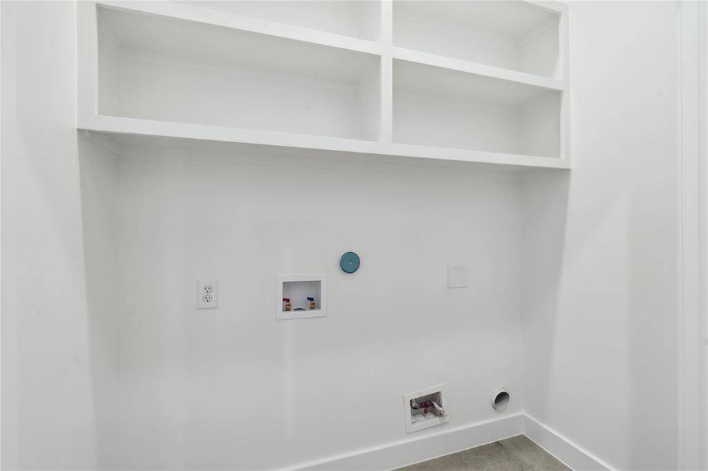 The spacious utility room is located on the second floor and comes standard with custom shelves.
