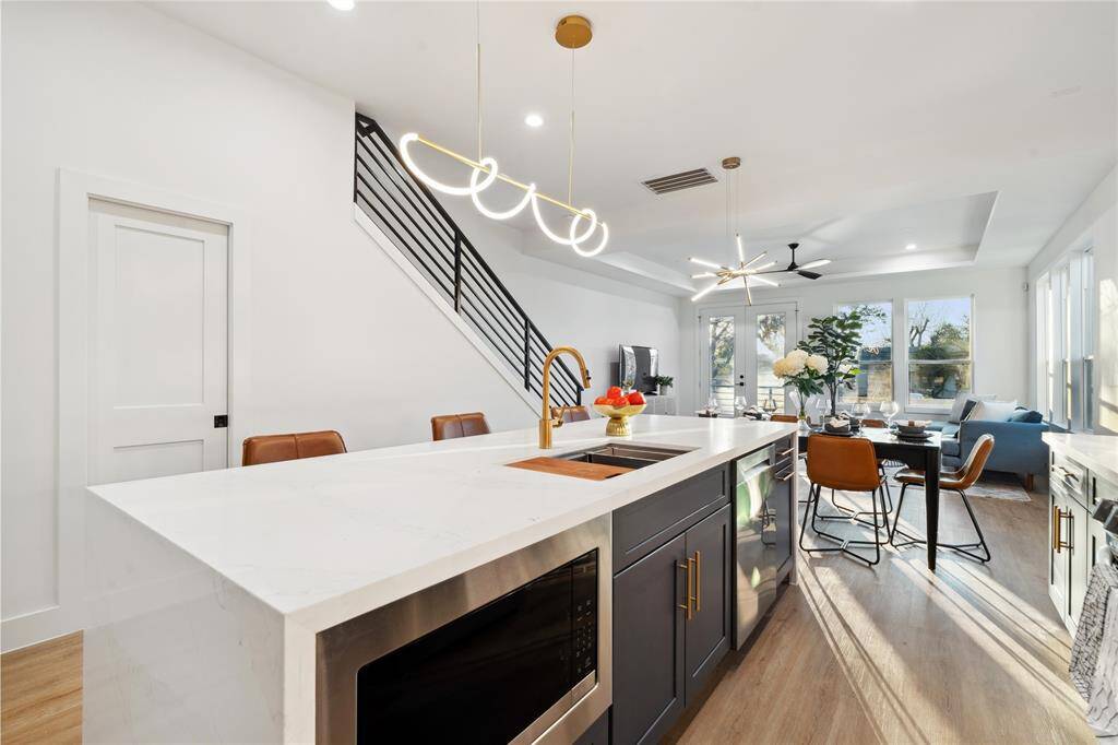 The island has plenty of room for seating with a one piece quartz island with flush microwave and deep farmhouse sink to accomodate alongside state of the art appliances.