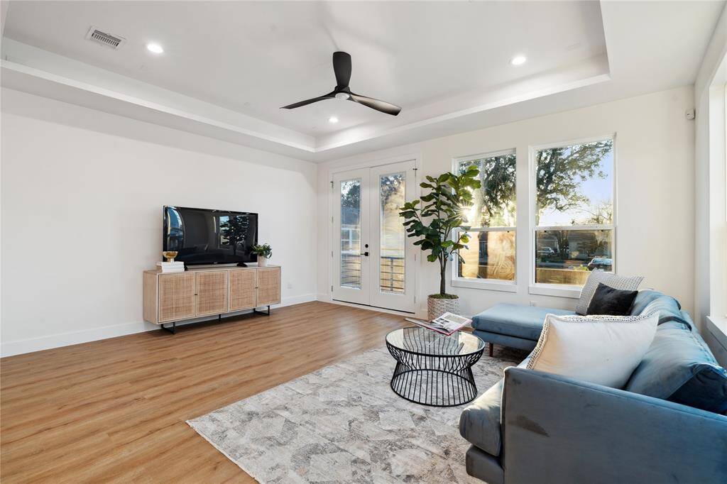 This living area features a large entertainment wall big enough for any size television or big screen while the natural light from an abundance of window give the perfect setting.