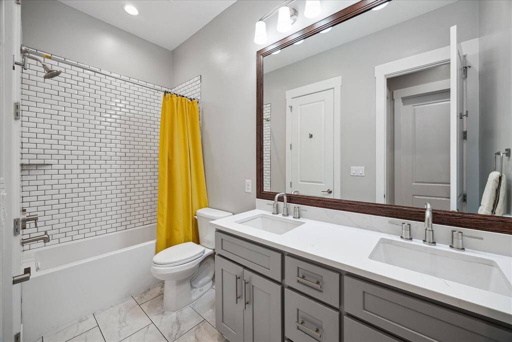 Luxurious en-suite bathroom with dual vanities, walk-in shower, and sleek finishes.
