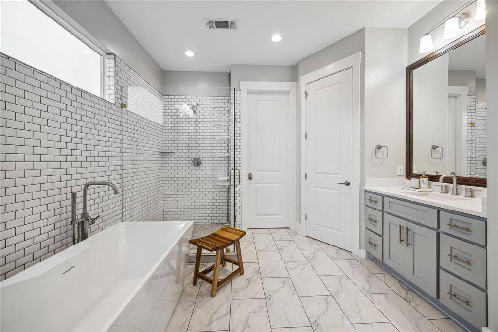 Spacious walk-in shower with decorative tile and clean, spa-like touches.