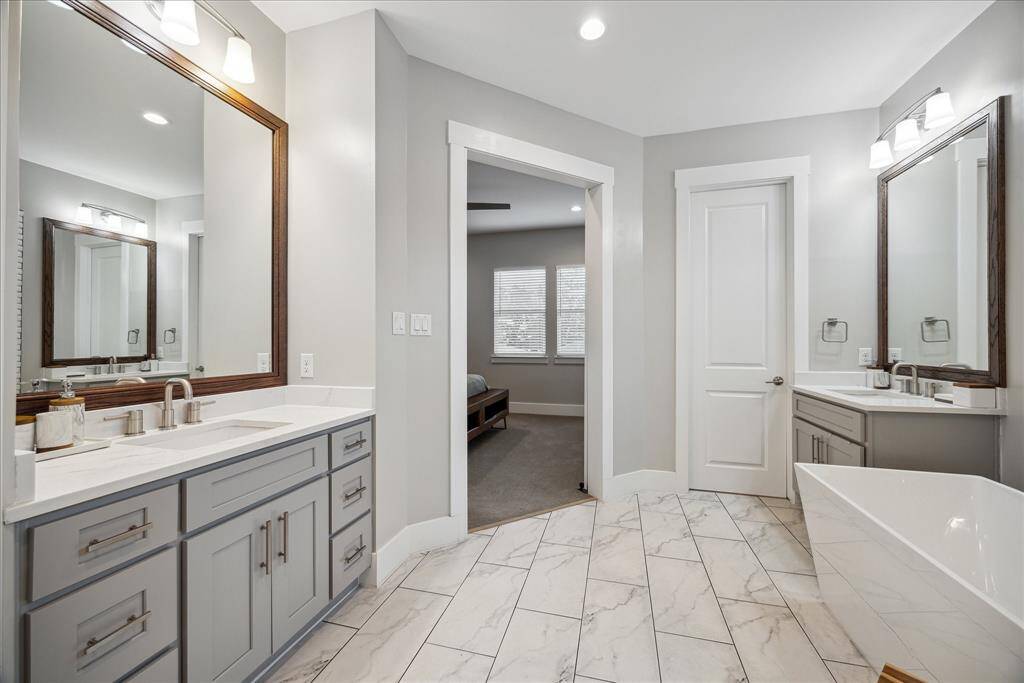 Bright dual-sink vanity area with ample storage and a clean, elegant aesthetic.