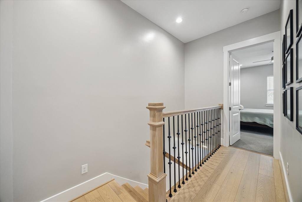Upstairs landing with recessed lighting and neutral tones, connecting the upper-level rooms.