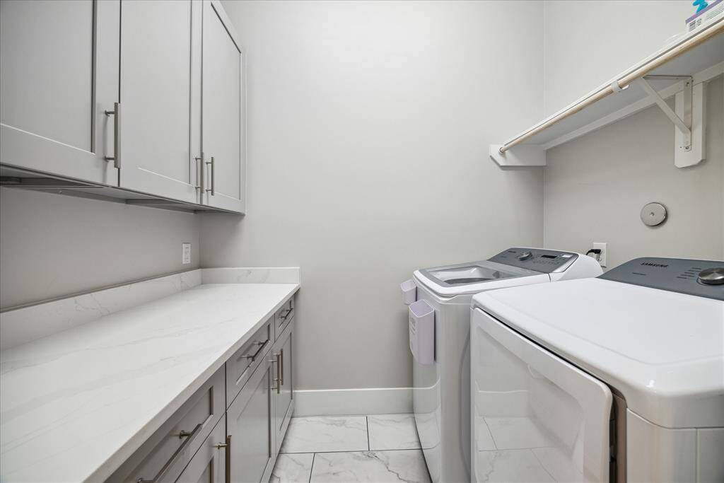 Laundry room with built-in storage, folding counter, and full-size washer/dryer.