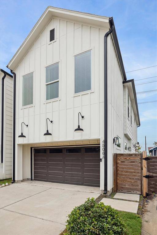 Modern multi-story home with sleek architecture and driveway access.
