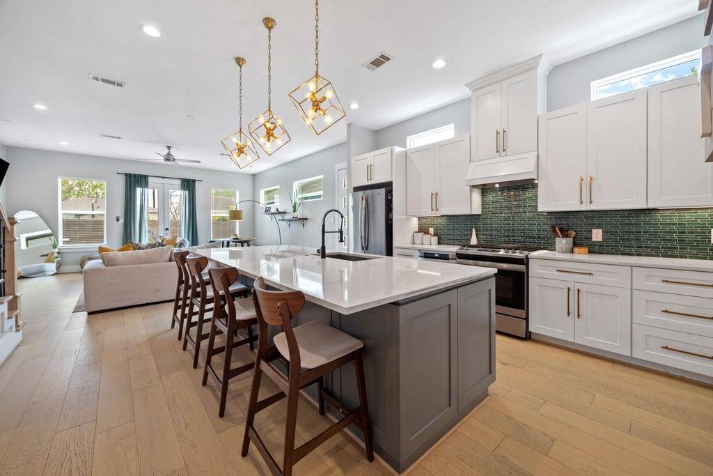 Bright and airy dining area with contemporary lighting and direct access to the chef’s kitchen.