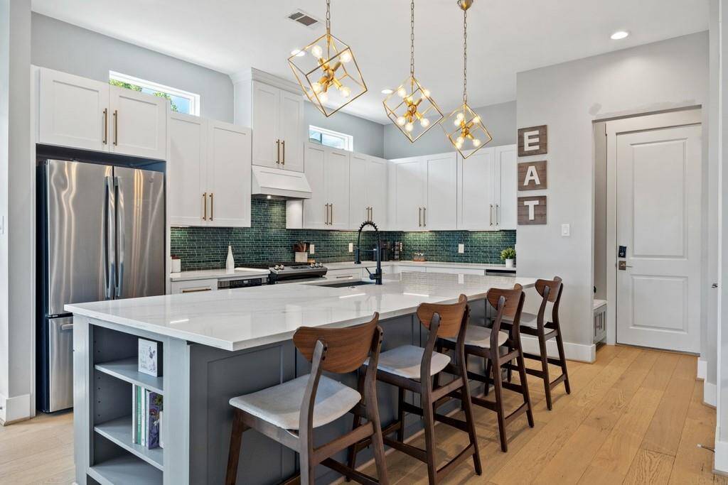 Beautifully designed kitchen island with bar seating, pendant lighting, and abundant cabinetry.