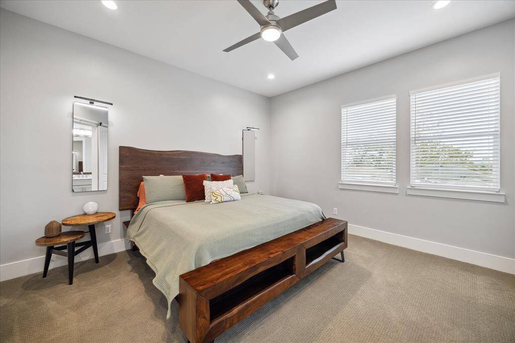 Primary bedroom filled with natural light, featuring high ceilings and serene ambiance.