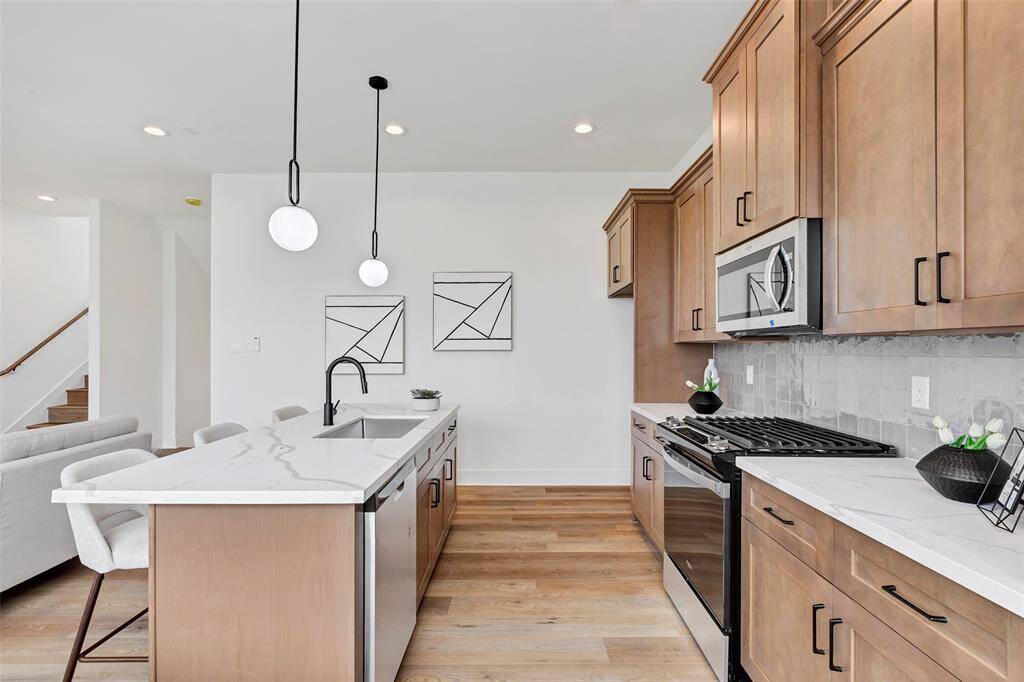 The elegant cabinetry that beautifully complements the rich tones of the flooring, creating a cohesive and warm aesthetic throughout the kitchen.