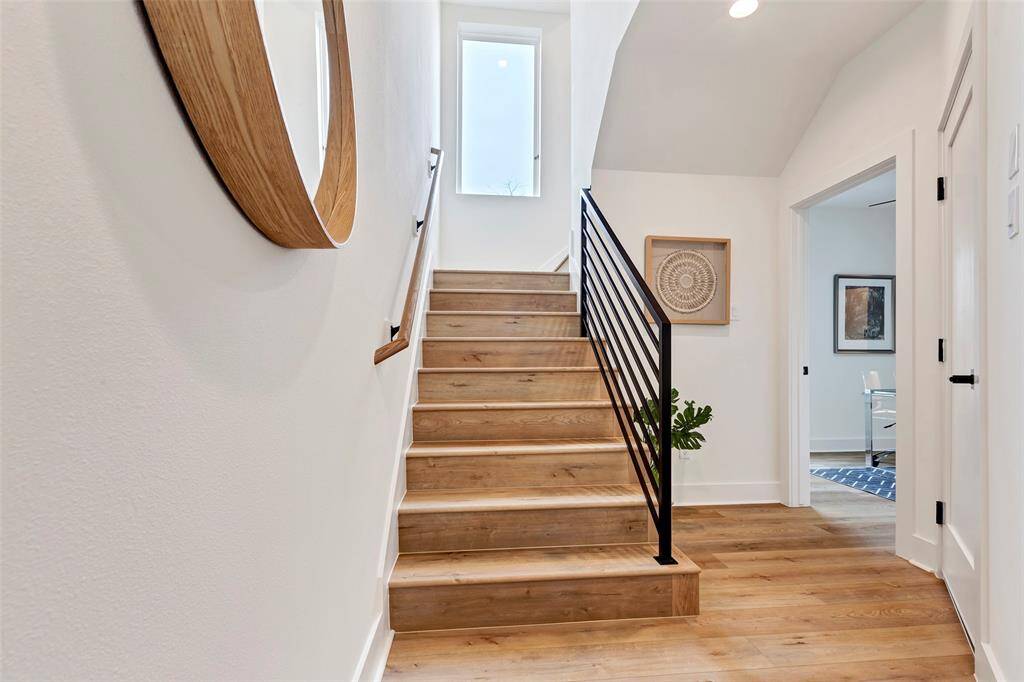 Welcoming main entrance with a spacious foyer, featuring a staircase that leads to the second floor. To the right, a cozy bedroom awaits.