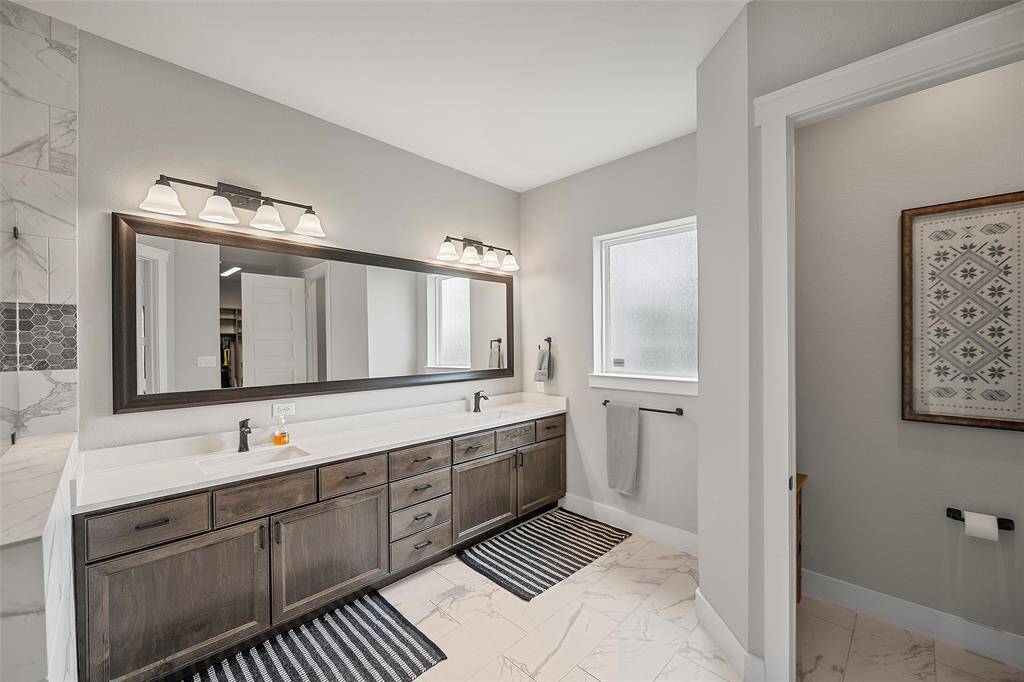 A timeless style en-suite bath with dual sink vanity, tons of cabinets and drawers for storage is perfect for sharing! The oversized shower has a Rain showerhead for the most relaxing of showers!