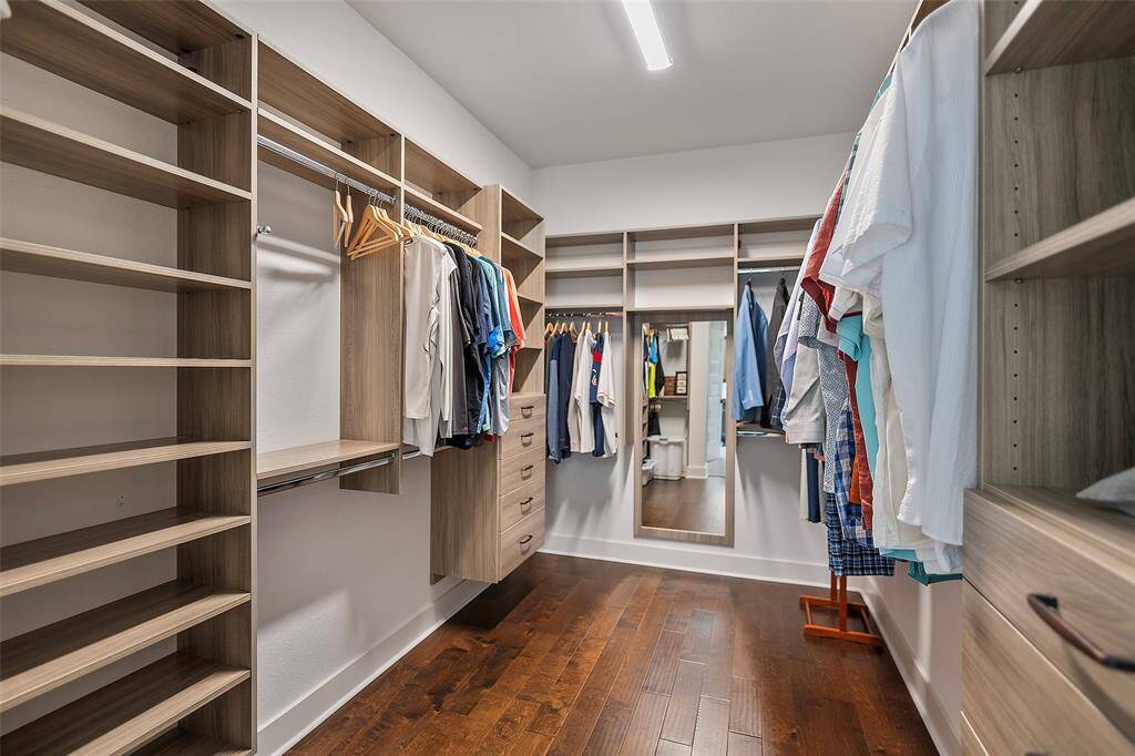 And look at this AMAZING primary closet with custom built-ins provides tons of space for hanging items, shoes, and a mirror to take a peep before heading out for the day!