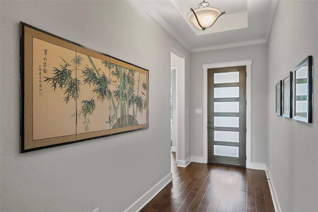 A light and bright entryway lends to a warm happy home, greeting all that enter into the space! Little details from the fabulous front door to the door molding, crown molding and tray ceiling with chandelier just beams withexcitement!