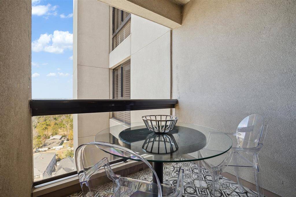 Second balcony off the kitchen, featuring matching tile flooring and views of the north treetops of Memorial Park