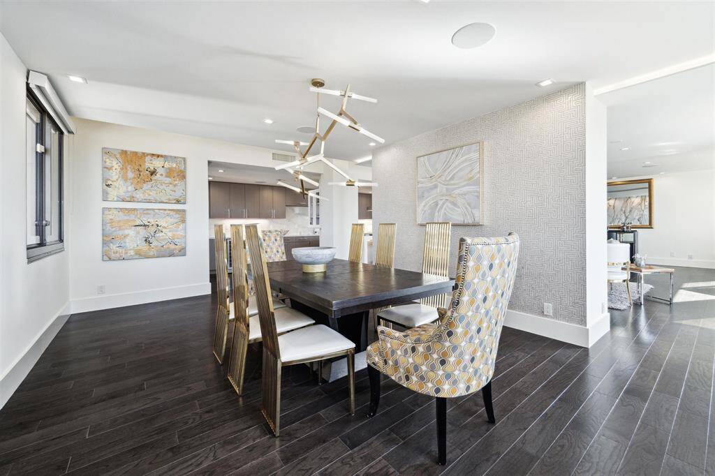 This beautifully designed unit offers a semi-open concept living space, providing a thoughtful separation between the living and dining areas—perfect for hosting gatherings or dinner parties. Despite the slight division, the continuous engineered hardwood floors, fresh neutral paint, and cohesive ceiling details throughout create a harmonious flow, making the entire space feel expansive and connected.