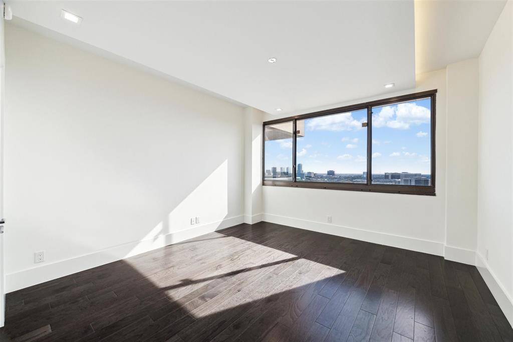 Another spacious secondary bedroom featuring a drop tray ceiling with integrated LED lighting, modern recessed lighting, and engineered hardwood floors. Enjoy sweeping views of the south side of the city.