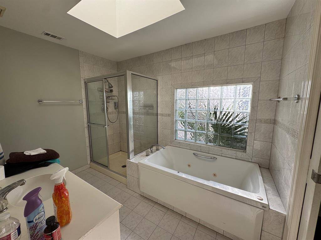 Primary bath with jetted tub, shower and skylight